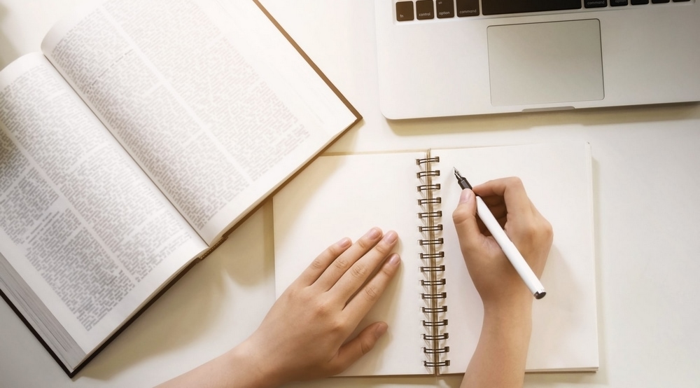 Livres et plume d'écriture évoquant les auteurs