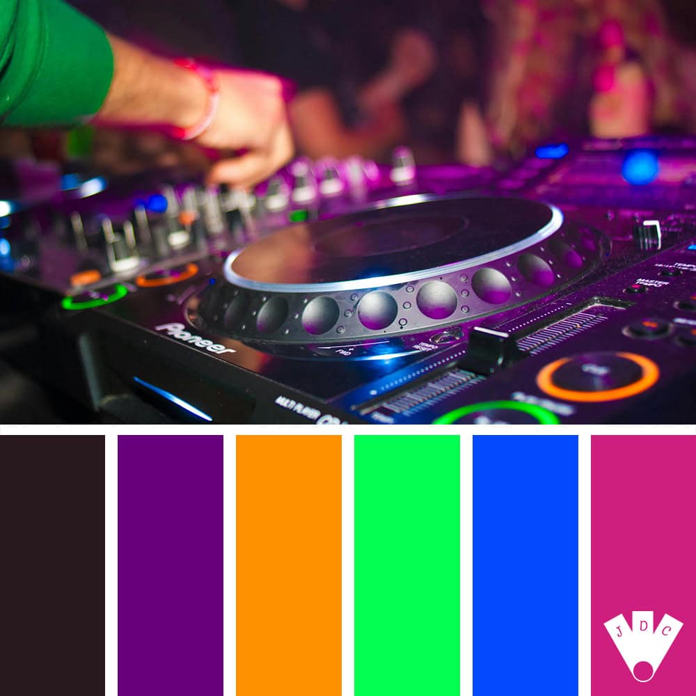 Main d’un DJ réglant une platine en soirée, ambiance lumineuse colorée