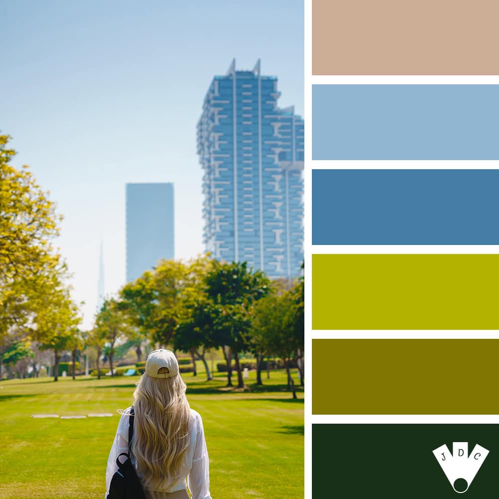 Jeune femme blonde marchant dans Zabeel Park à Dubaï, entre arbres et gratte-ciel.
